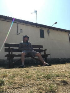 Matt Miller sitting on a bench wearing a hoodie