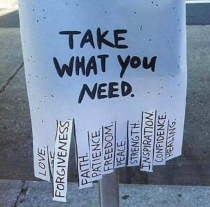 Photo of a sign that says 'Take what you need' with tear-off strips of paper each bearing a different word